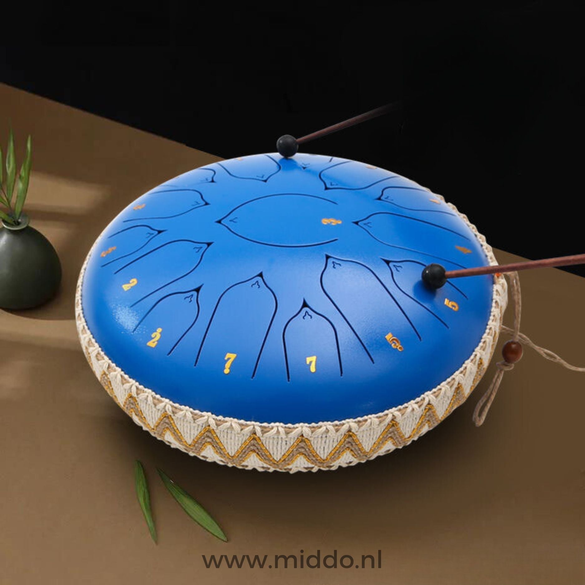 Handen bespelen een blauwe Harmonii KlankOase Steel Tongue Drum met mallets