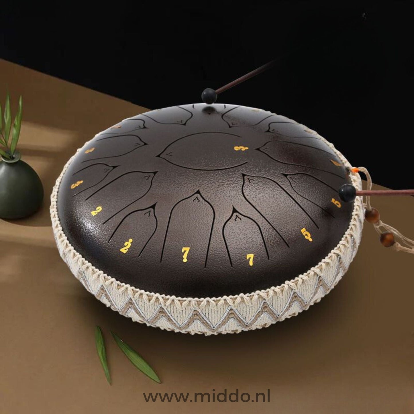Handen bespelen een bronzen Harmonii KlankOase Steel Tongue Drum met mallets